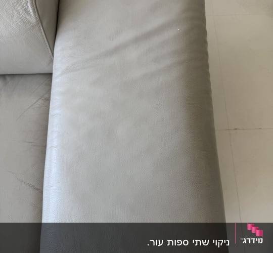 ספה אפורה עם ריפוד עור על רצפה בהירה